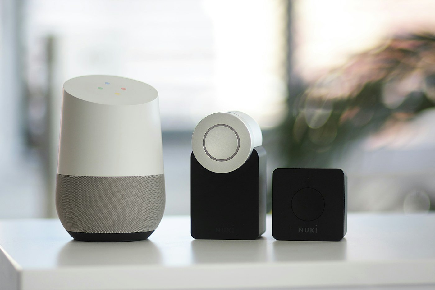 Three compact smart speakers on a white surface