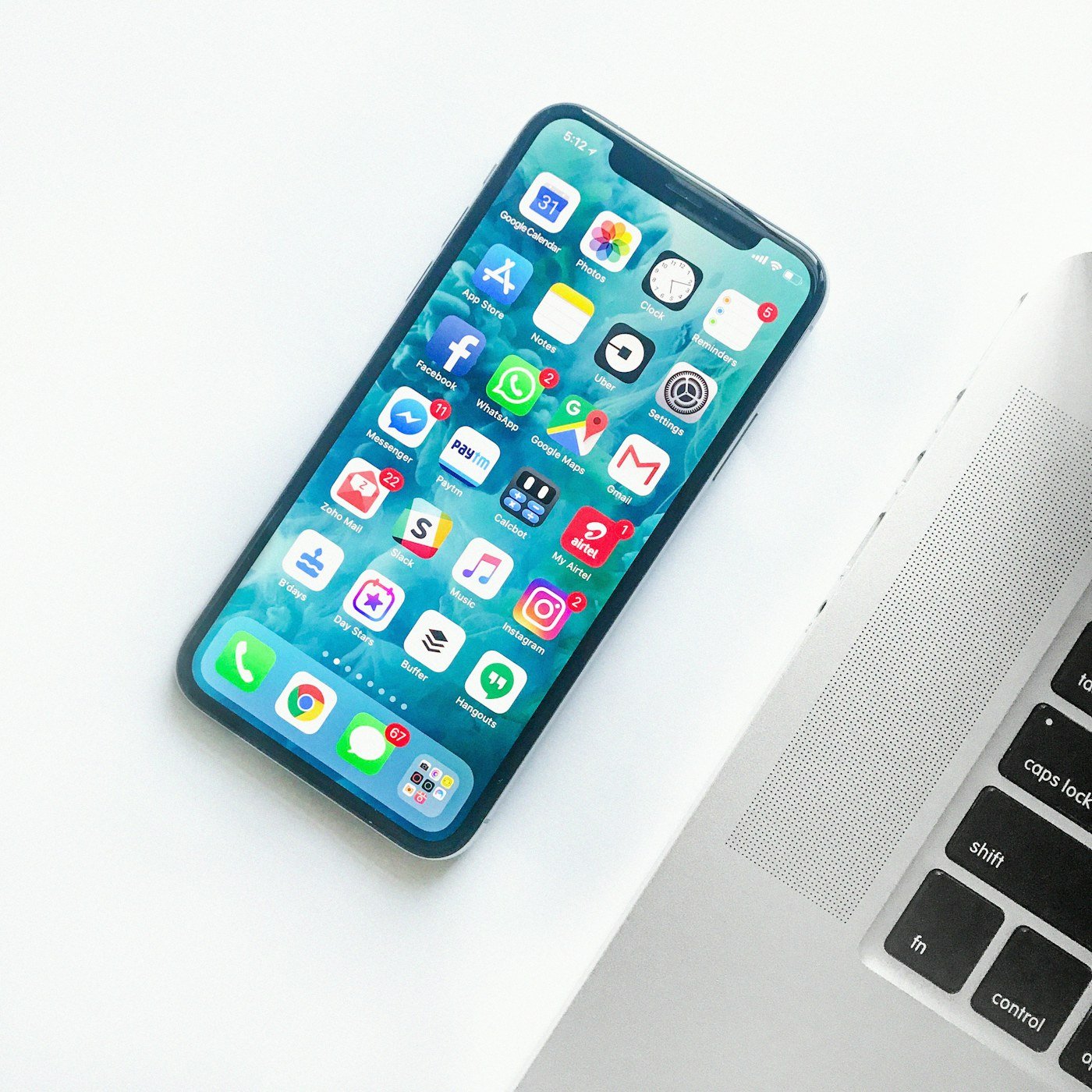 Smartphone lying on a desk beside a laptop
